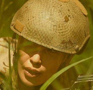 Woman in military uniform sitting in grass